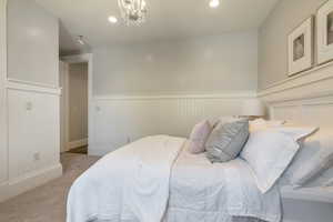 Bedroom featuring an inviting chandelier and carpet