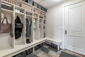 Mudroom featuring wooden walls