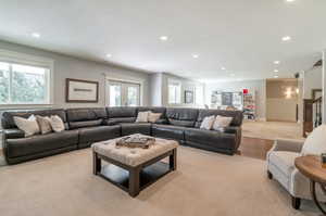 Living room with french doors, light colored carpet, a textured ceiling, and plenty of natural light