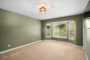 Carpeted spare room with a textured ceiling