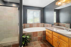 Bathroom featuring vanity and separate shower and tub