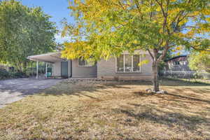 View of front of house featuring a front lawn and a carport