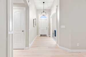 Interior space with light wood-type flooring and a chandelier