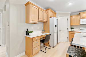 Kitchen featuring white appliances, light brown cabinetry, and light hardwood / wood-style flooring