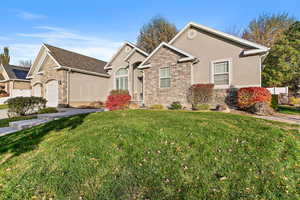 View of front of property featuring a front yard and a garage