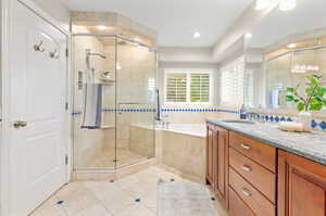 Bathroom with plus walk in shower, vanity, and tile patterned floors