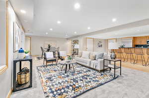 Living room featuring light wood-type flooring and bar