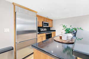 Kitchen with light hardwood / wood-style floors and appliances with stainless steel finishes