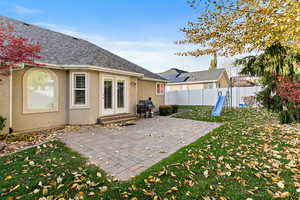 Back of house with a yard and a patio area