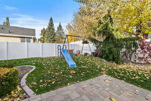 View of yard with a playground and a patio