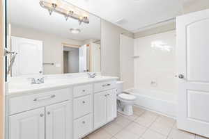 Full bathroom with tile patterned floors, vanity, toilet, and tub / shower combination