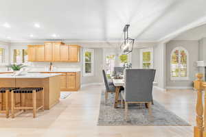 Dining room featuring crown molding, light hardwood / wood-style flooring, and a chandelier