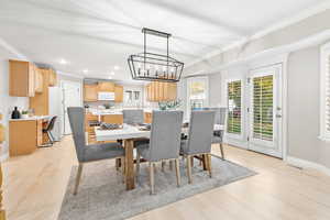 Dining room featuring a chandelier, crown molding, and light hardwood / wood-style floors