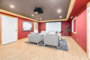 Cinema room featuring hardwood / wood-style floors and ornamental molding