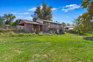 Rear view of property with a yard