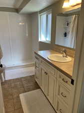 Bathroom featuring curtained shower, vanity, toilet, and tile patterned floors