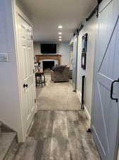 Hall with a barn door and dark wood-type flooring