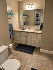 Bathroom featuring vanity, tile patterned flooring, and toilet