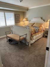 Carpeted bedroom featuring a textured ceiling and ornamental molding