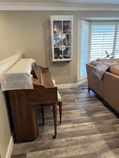 Misc room with crown molding and dark wood-type flooring