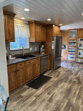 Kitchen featuring appliances with stainless steel finishes, wood ceiling, and dark hardwood / wood-style flooring