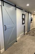 Staircase with a barn door and carpet floors