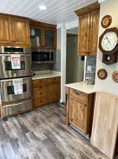 Kitchen featuring decorative backsplash, appliances with stainless steel finishes, and dark hardwood / wood-style flooring