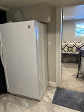 Interior space with white refrigerator and light colored carpet