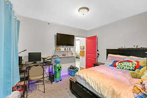 Bedroom with light carpet and a textured ceiling