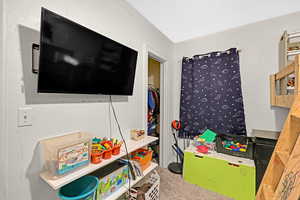 Rec room featuring carpet and a textured ceiling