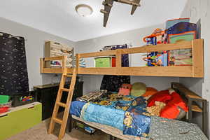 Bedroom with carpet and a textured ceiling