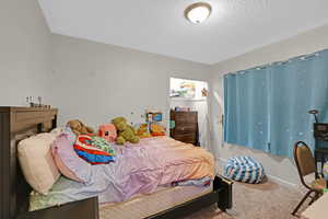 Bedroom with carpet and a textured ceiling