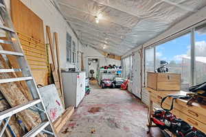 Miscellaneous room featuring vaulted ceiling and concrete flooring