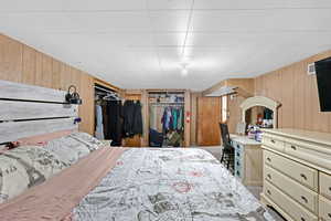 Bedroom with a closet and wooden walls