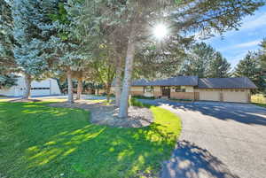 View of front of property with a garage and a front lawn