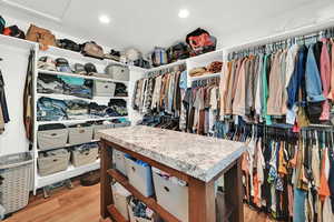 Walk in closet with light wood-type flooring