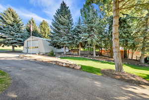 View of front of home featuring a front yard, a garage, and an outdoor structure