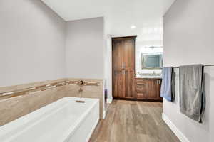 Bathroom featuring a bathtub, vanity, and hardwood / wood-style floors