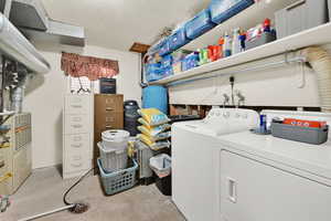 Laundry room with a textured ceiling and washing machine and dryer