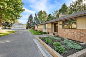 Ranch-style home featuring a garage and an outbuilding