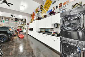 Washroom featuring stacked washer / drying machine, sink, and ceiling fan