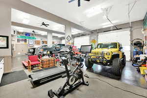 Interior space featuring a garage door opener and ceiling fan