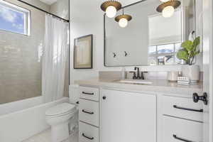 Full bathroom featuring vanity, toilet, and shower / bathtub combination with curtain