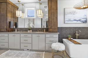 Bathroom featuring vanity, tile patterned flooring, tile walls, and a tub