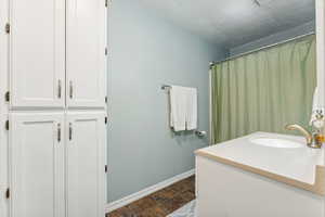 Bathroom featuring a textured ceiling, tile patterned flooring, and vanity