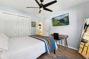 Bedroom with ceiling fan, a closet, and hardwood / wood-style flooring