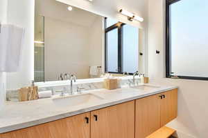 Bathroom featuring vanity, vaulted ceiling, and an enclosed shower