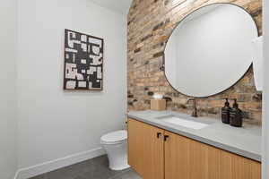 Bathroom with toilet, vanity, and tile patterned floors