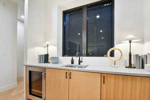 Interior space with light hardwood / wood-style floors, sink, and wine cooler