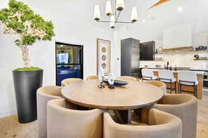 Dining area with light hardwood / wood-style floors and an inviting chandelier